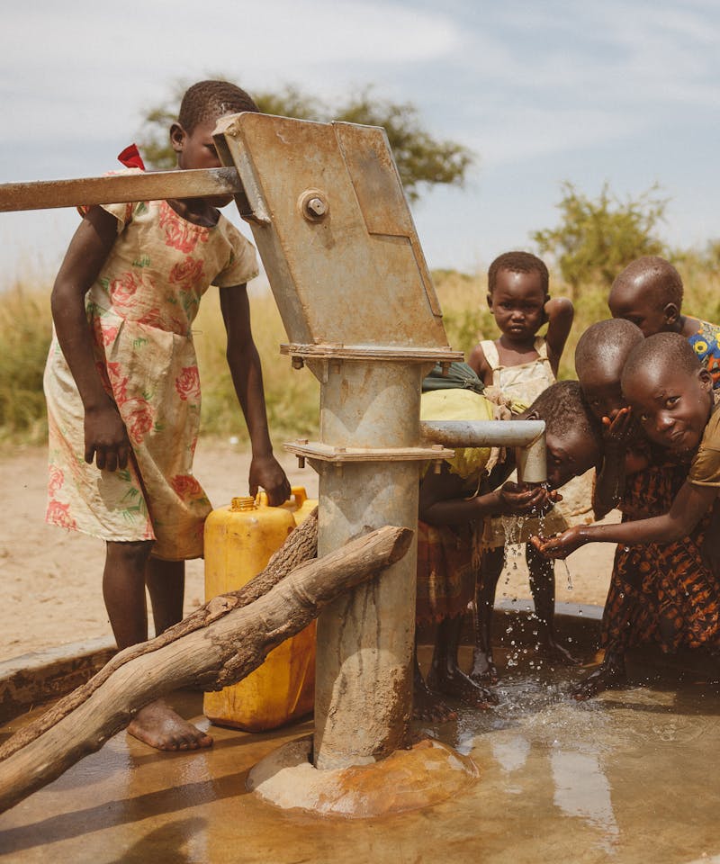 Group of children gathering water from a well in Kitgum, Uganda.